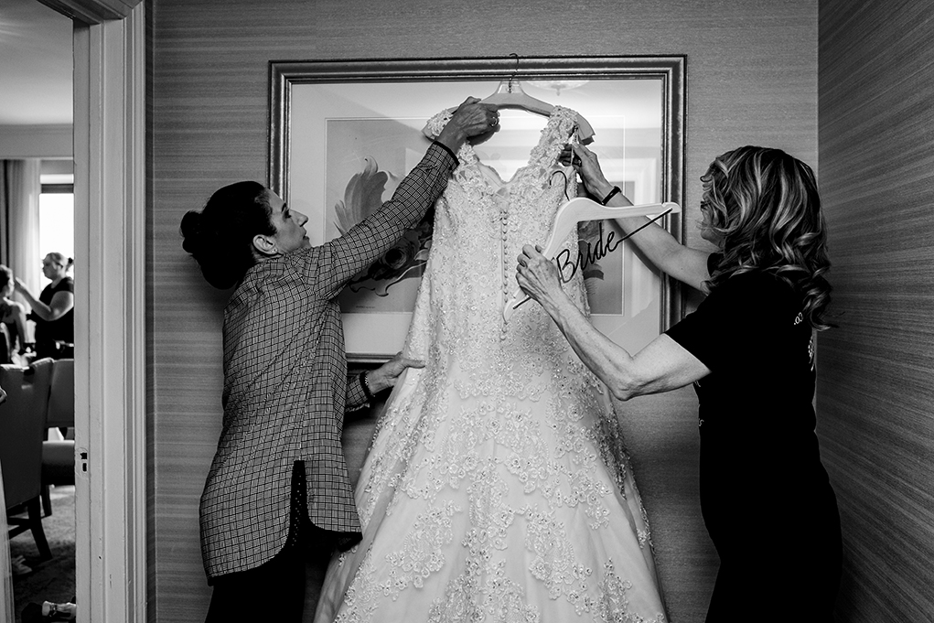 Mother of the bride and aunt hanging wedding dress atOmni Shoreham DC wedding by photographers Potok's World Photography