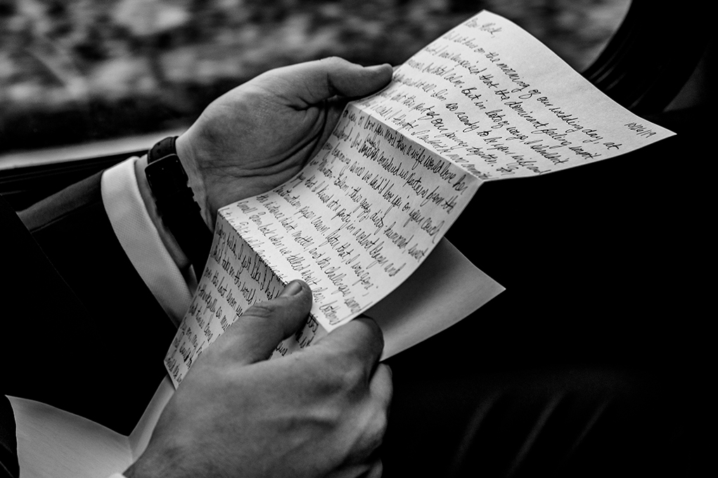 Groom reads letter on bus on the way to wedding ceremony after leaving Omni Shoreham by DC wedding photographers Potok's World Photography