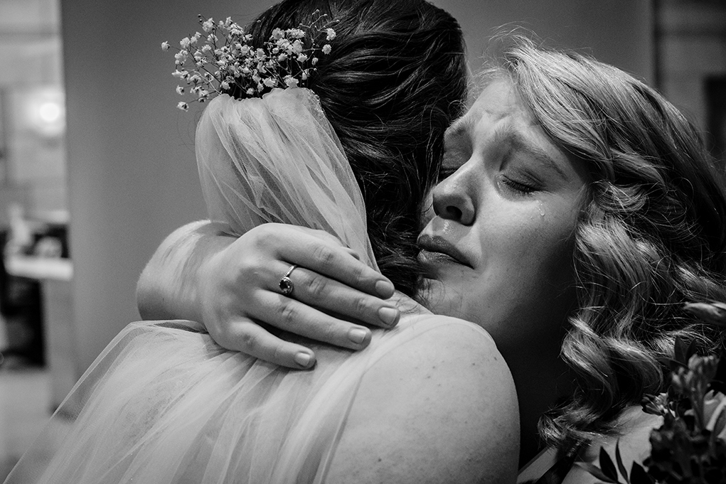 Sister and bridesmaid of the bride congratulating her after wedding ceremony at City Club Washington by DC wedding photographers Potok's World Photography