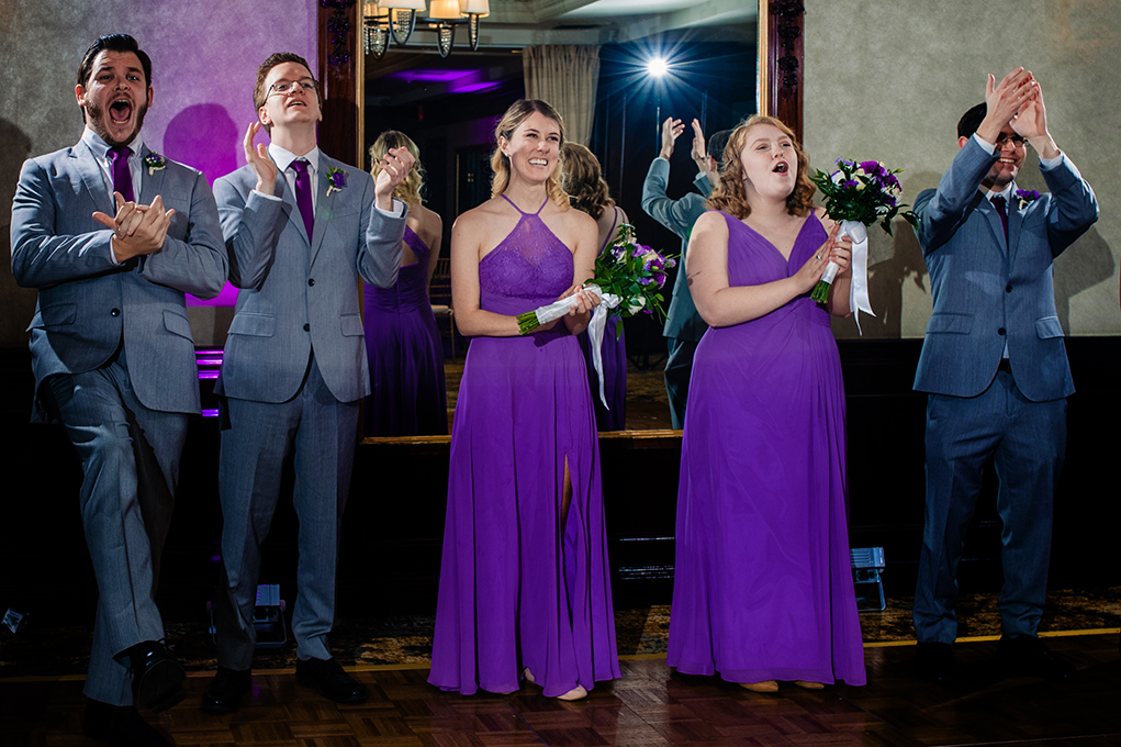 Bridal party cheering brides on as they walk in for their first dance at City Club of Washington by DC wedding photographers Potok's World Photography