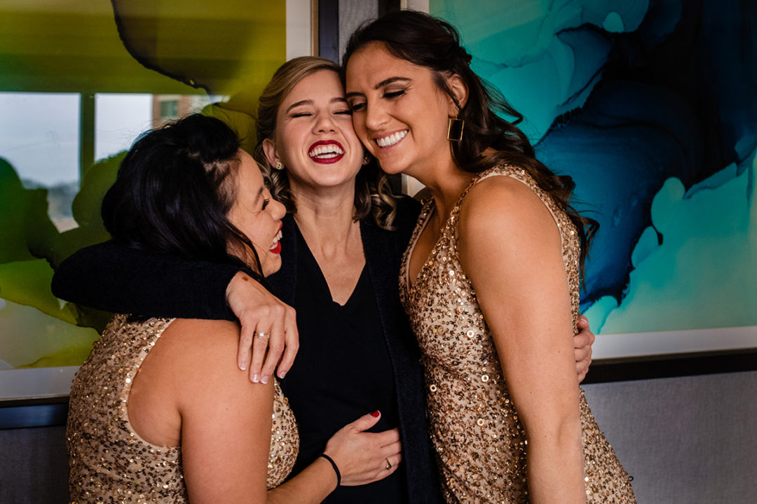 Bride is sharing a moment with her bridesmaids while getting ready at the Westin in Old Town Alexandria by DC wedding photographers of Potok's World Photography