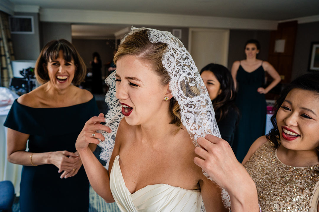 Bride having a moment with her mother and bridesmaid while wearing her grandmother's veil at the Westin in Old Town Alexandria by DC wedding photographer Potok's World Photography