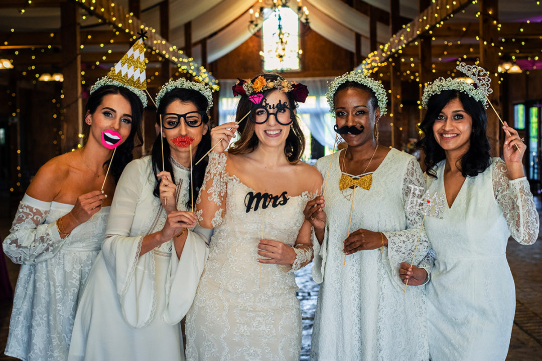 Wedding day timeline: Funny picture of bride with bridesmaids with props at Bluemont Vineyard in Virginia by DC wedding photographer Potok's World Photography