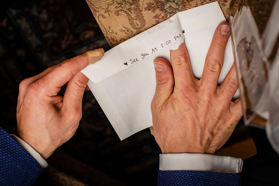 Groom reading letter from bride before their church wedding ceremony and reception at the Carlyle Club Alexandria by DC wedding photographers Potok's World Photography