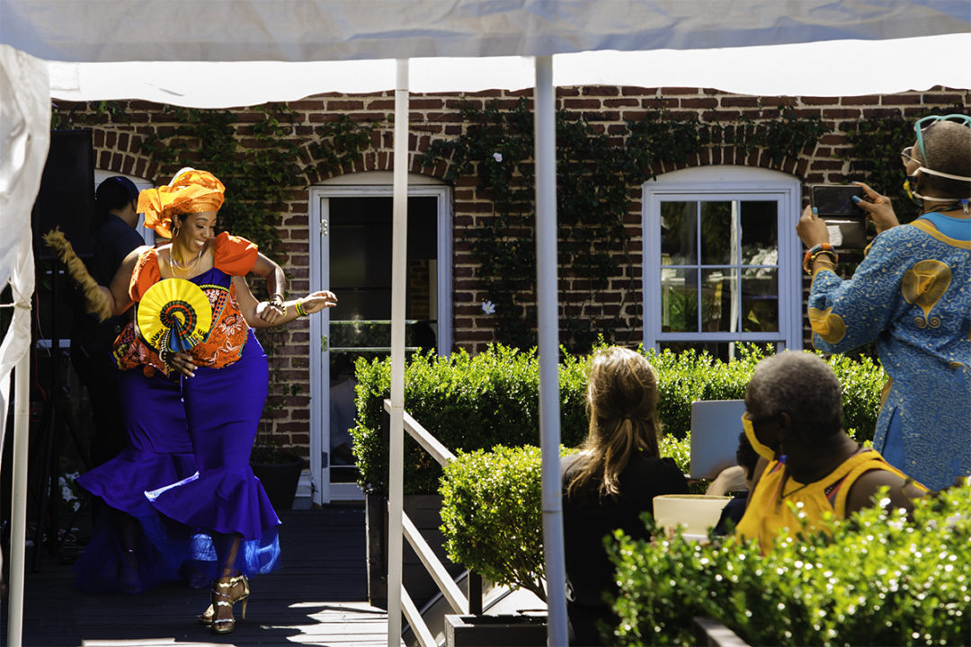 Bridesmaids in ghanaian dresses dancing to African pop music during a Washington DC micro wedding at Fathom Gallery by DC wedding photographers Potok's World Photography