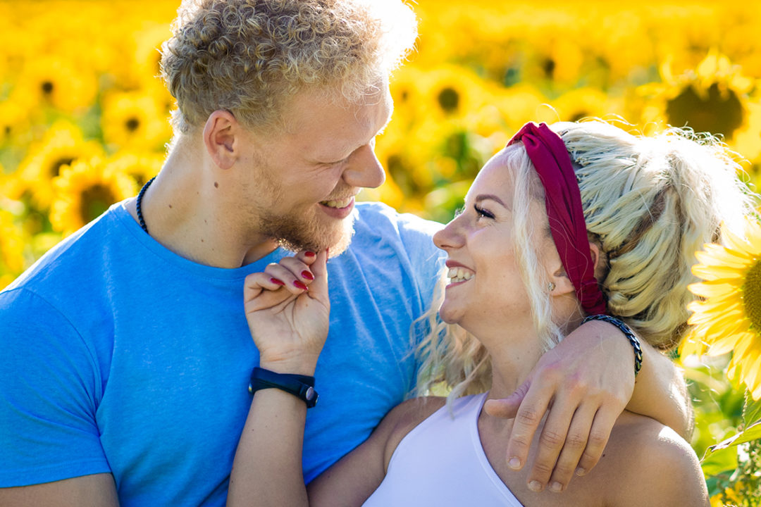 Photos of couple posing in sunflower field during engagement session by DC wedding photographers of Potok's World photography