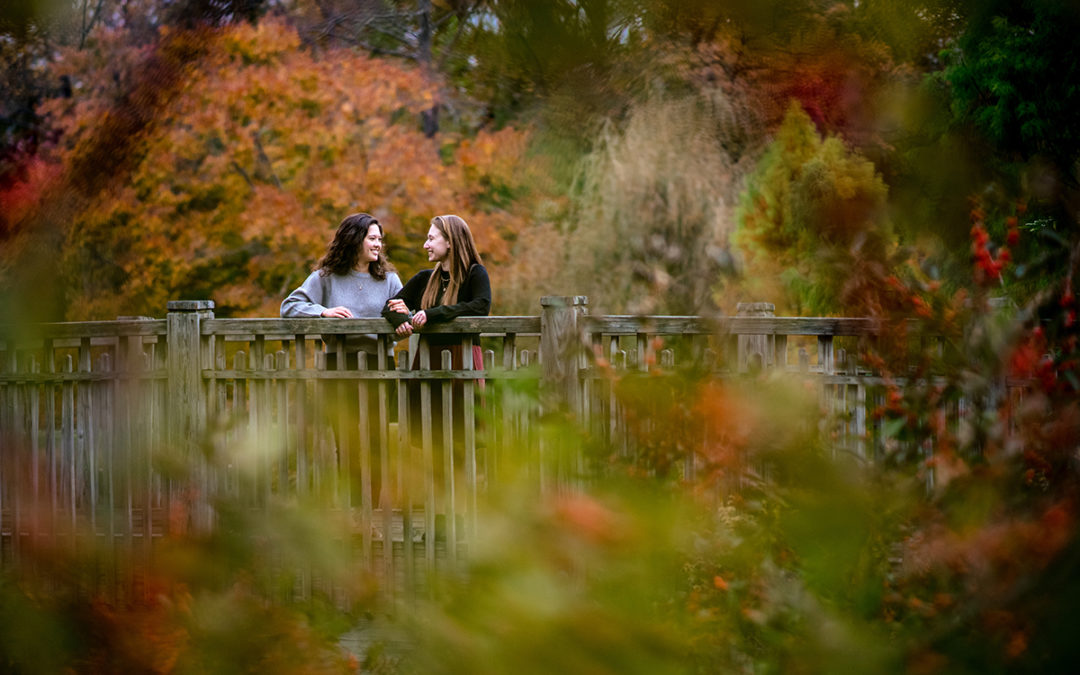 Two brides posing during their fall color engagement session at the Brookside Gardens in Maryland by Potok's World Photography
