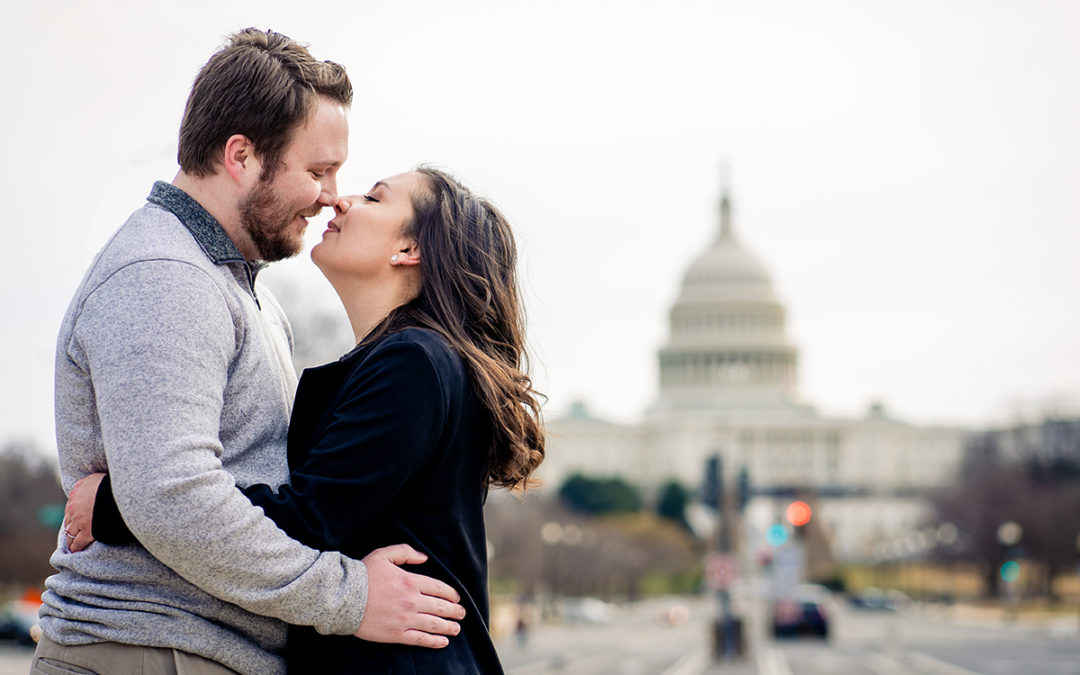 Couple posing for Freedom Plaza winter engagement session with a view of the Capitol Building in DC by Potok's World Photography