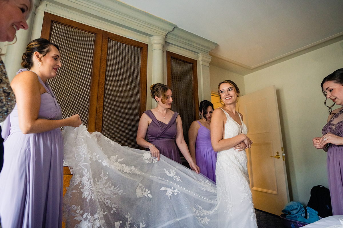 Bride getting ready at the St. Regis in Washington DC by getting into her wedding dress before her ceremony by Potok's World Photography