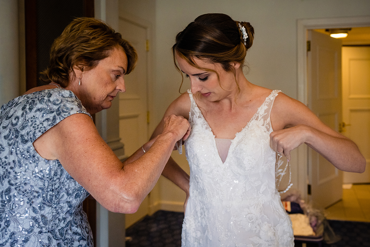 Bride getting ready at the St. Regis in Washington DC by getting into her wedding dress before her ceremony by Potok's World Photography