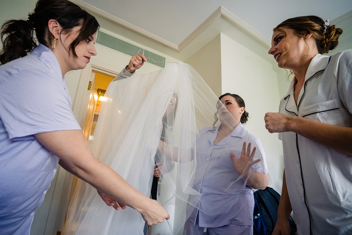 Bride getting ready at the St. Regis in Washington DC by getting into her wedding dress before her ceremony by Potok's World Photography